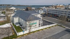 Un edificio con techo plano, estacionamiento cercado y vista al mar.