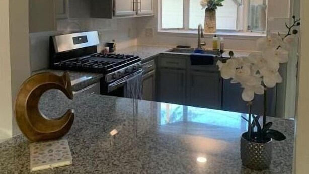 Una cocina con encimeras de granito, estufa y ventana con vistas.
