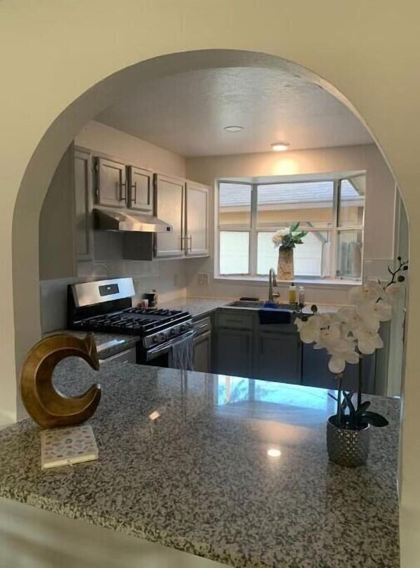 Enjoy cooking in this clean, minimalist kitchen with a central island and natural light.