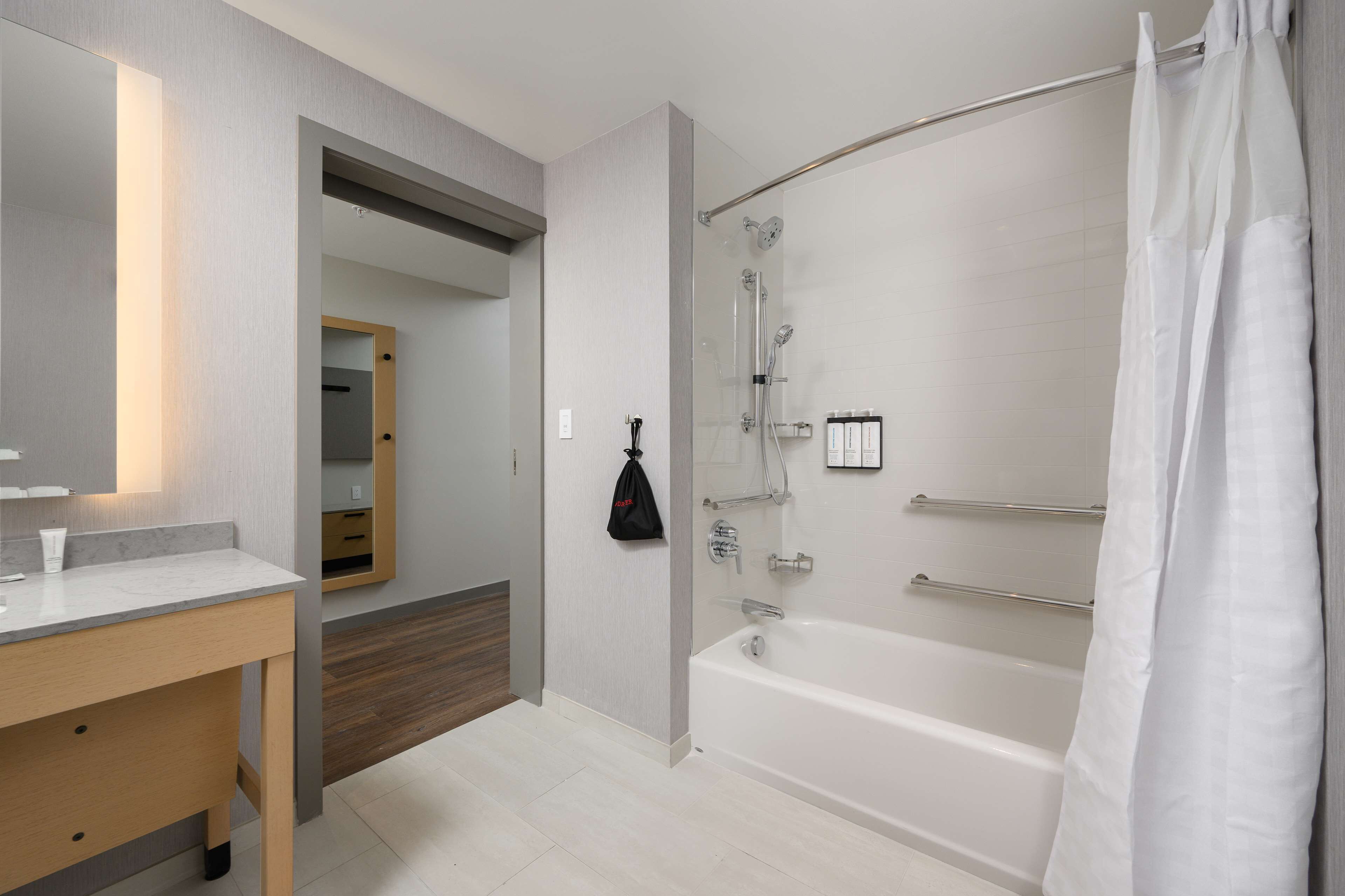 A modern bathroom with a bathtub, a shower, and a vanity with a mirror.