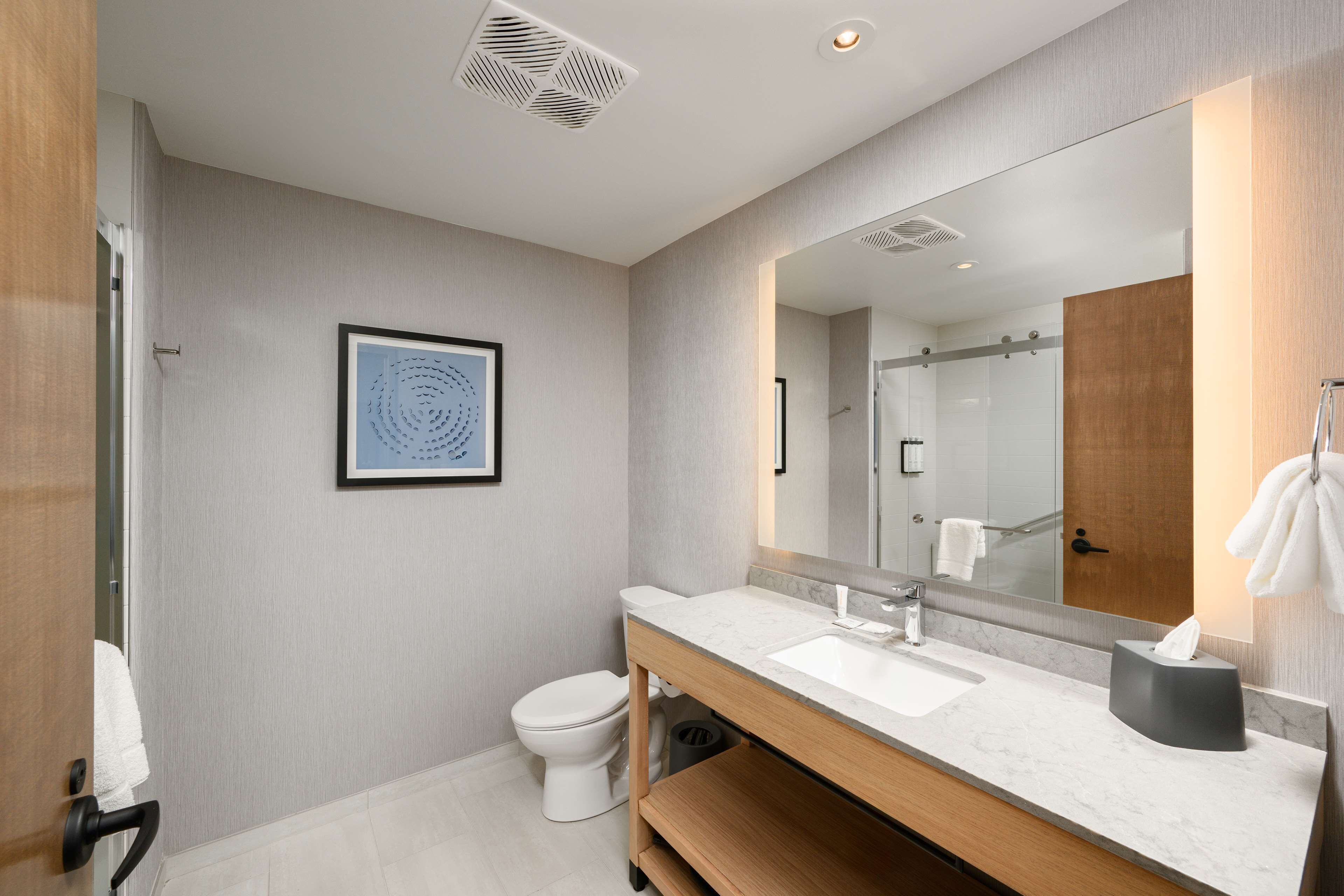 Un baño moderno con inodoro, lavabo y espejo.