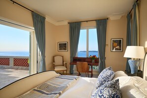 Ein Hotelzimmer mit Bett, Schreibtisch, Stuhl und Meerblick.