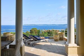A balcony with a view of the sea, lounge chairs, and potted plants. - Le Belvedere - Nine Bedroom Villa, Sleeps 22 (Sainte-Maxime)