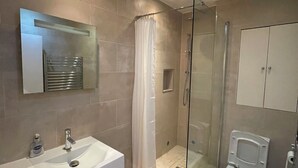 A modern bathroom with a glass-enclosed shower, a white sink, and a toilet. - Cosy 1BD Hideaway in Paddington (London)