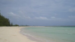 Ein Strand mit klarem türkisblauem Wasser und einem sandigen Ufer.