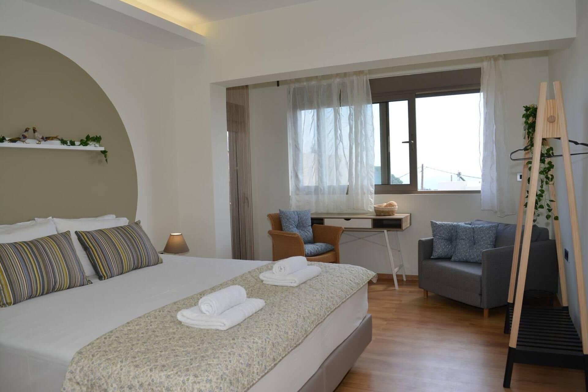 A modern bedroom with a large bed, a desk, and a chair.
