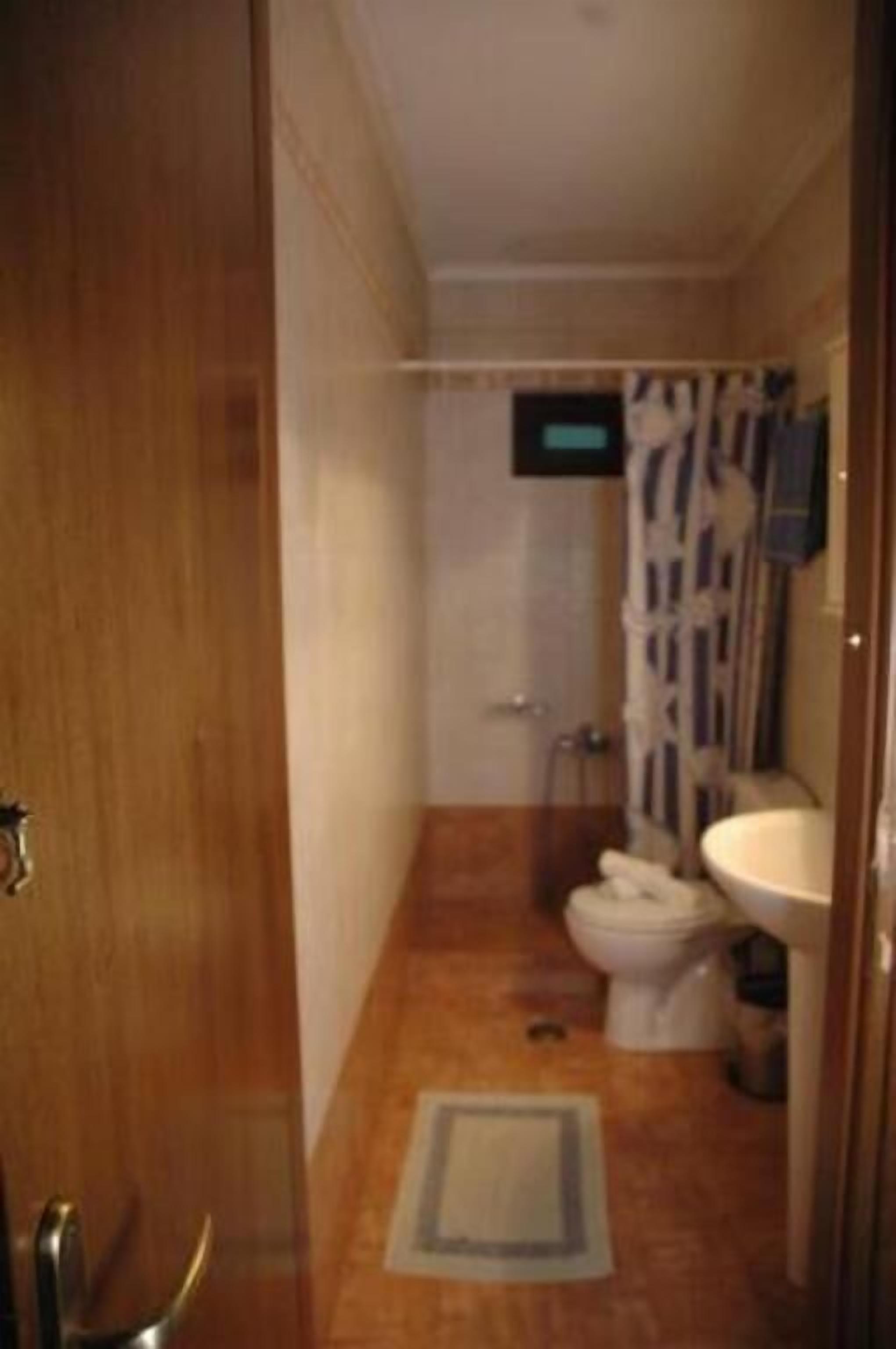 Un bagno piccolo con il water, il lavandino e la doccia.
