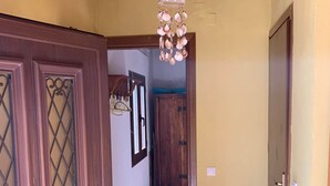 A hallway with wooden doors and a hanging light fixture.