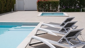 A pool area with three white lounge chairs and a small pool. - Contemporary modern apartment [119] (Lagos)