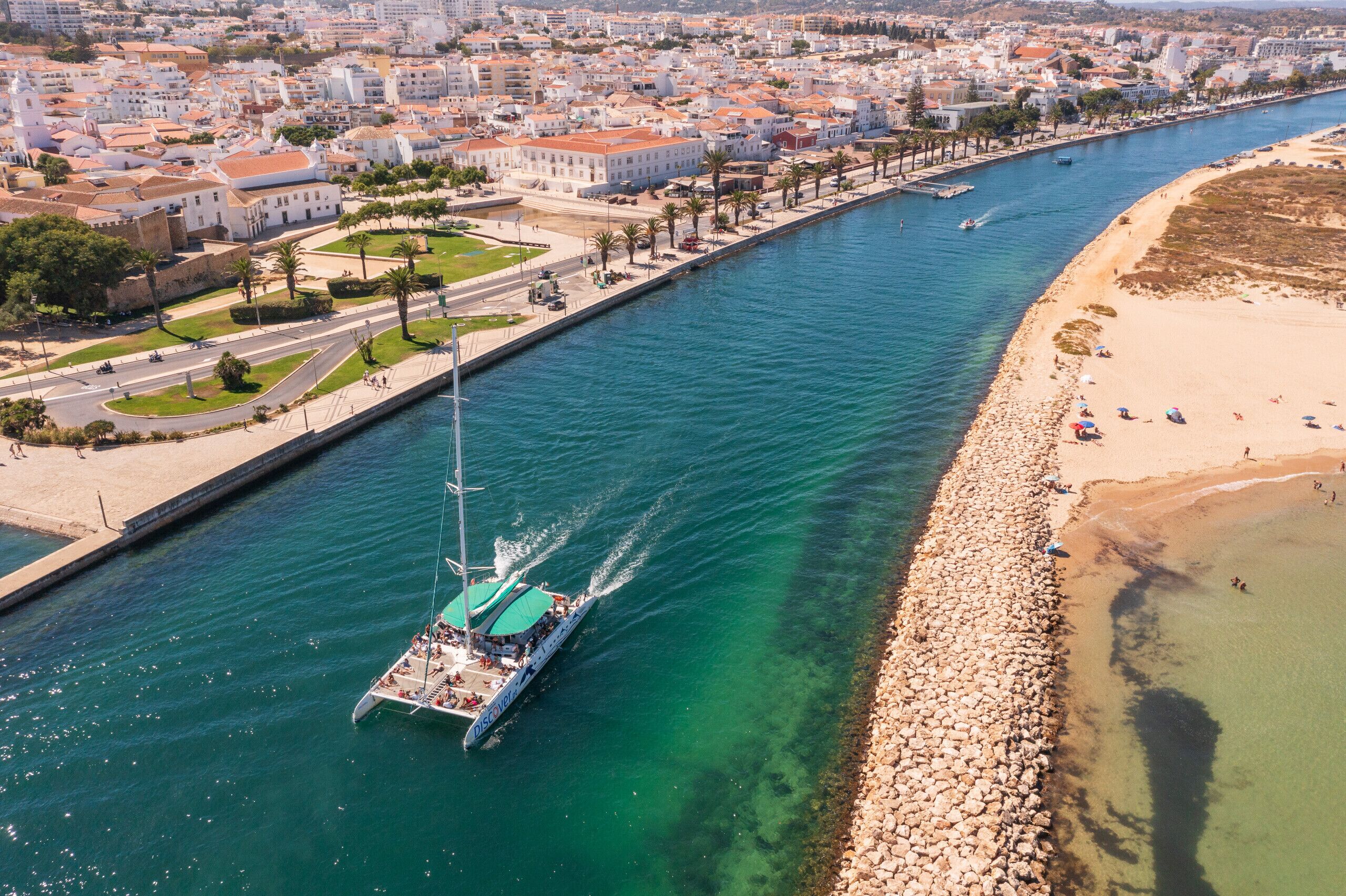 Un paysage urbain côtier avec une rivière, un bateau et une plage.