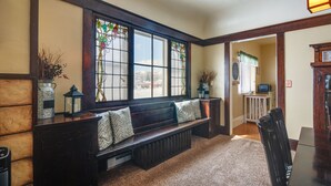 A cozy room with a wooden bench, a radiator, and a window with stained glass. - Beautiful Historic Home Near Bryce Canyon! (Cannonville)