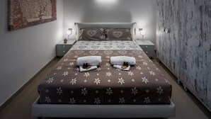 Ein ordentlich eingerichtetes Schlafzimmer mit einem großen Bett, zwei Nachttischen, einem Wandleuchten und einem Kleiderschrank.