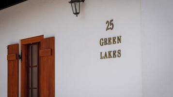 A building with a wooden door and a sign reading "25 GREEN LAKES".