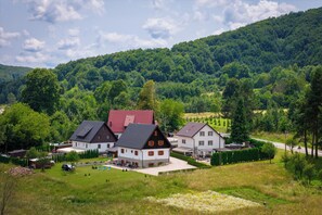 A rural village with houses, a road, and a forested hill. - Green lakes house 2 (Plitvicka Jezera)