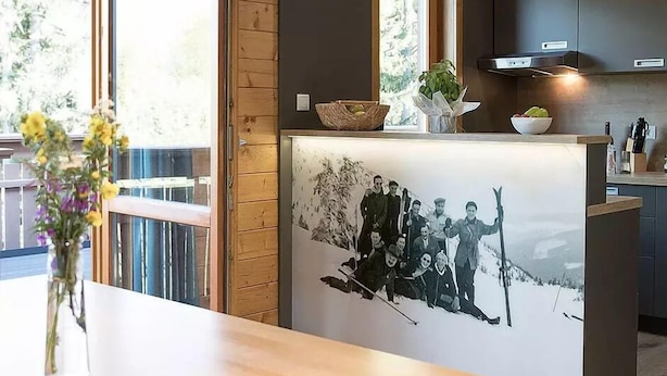A modern kitchen with wooden beams, a large window, and a black and white photo on the wall. - Berg- & Erlebnis-Resort MarktlAlm - Chalets & Lodges (Stadl-Predlitz)