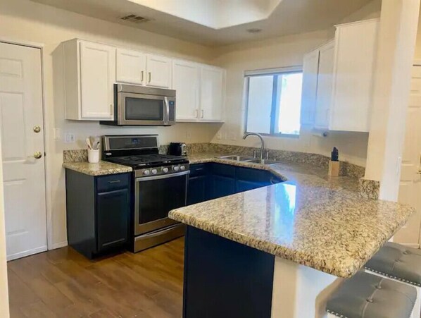 A kitchen with a built-in island, stainless steel appliances, and a window providing natural light. - Location, Leisure, & Luxury (Scottsdale)