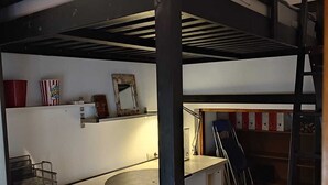 Camera con letto a castello, scrivania, sedia e scaletta.