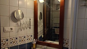 Un bagno con lavandino, specchio e doccia.