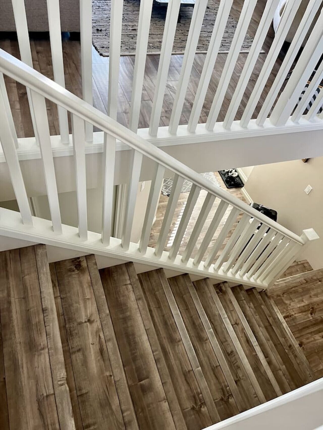 A wooden staircase with white railings leading to an upper floor.