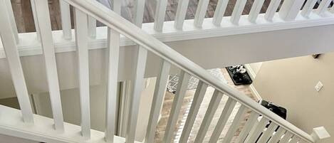 A wooden staircase with white railings leading to an upper floor.