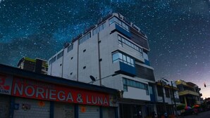 A building with a sign reading "NORIEGA & LUNA" and a starry night sky in the background. - Hotel Luna Azul  (Florencia)