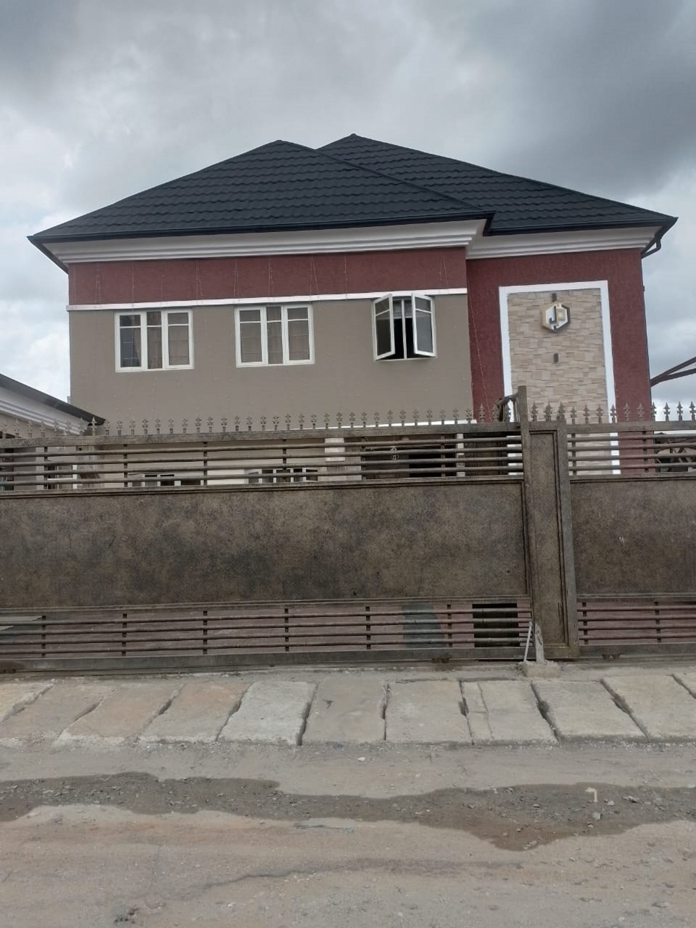 Ein zweistöckiges Gebäude mit dunklem Dach und einer beige farbenen Fassade.