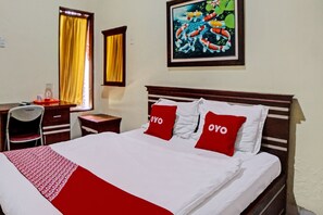 A hotel room with a bed, a desk, a chair, and a painting on the wall. - OYO 92430 Anora Homestay (Medan)