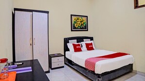 A bedroom with a bed, a nightstand, a wardrobe, and a framed picture on the wall. - OYO 92430 Anora Homestay (Medan)