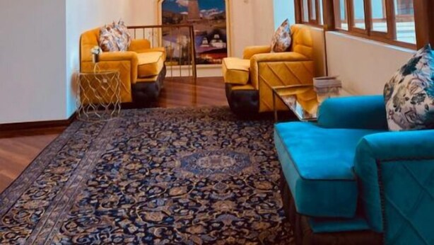 A spacious lobby with a grand chandelier, a patterned carpet, and a view through a large window. - Catedral Internacional (Quito)