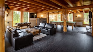 A spacious indoor area with a pool table, leather sofas, and a billiards table. - Red Cariboo Resort (Anahim Lake)