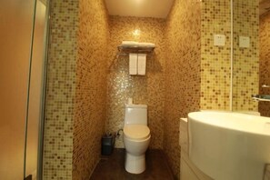 Un baño pequeño con inodoro, lavamanos y espejo.
