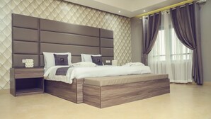 Un dormitorio moderno con una cama grande, una mesita de noche y un banco empotrado.