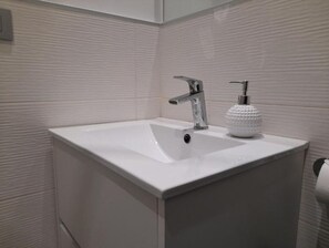Chuveiro, secador de cabelo, toalhas de banho, sabonete