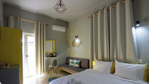 A bedroom with a bed, a desk, a chair, and a sofa. - Hotel Jonian (Sarandë)