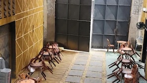 A courtyard with outdoor seating, a tiled floor, and a large gate. - Mike's Flat hotel (Kinshasa)