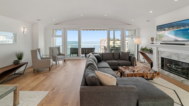 A spacious living room with a large sofa, a fireplace, and a television.