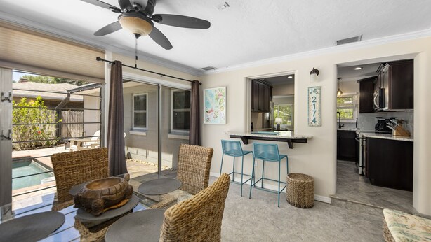 A spacious patio with wicker furniture, a ceiling fan, and a view of the backyard. - Casa Tortuga - tropical getaway & central to many amenities! (Sarasota)