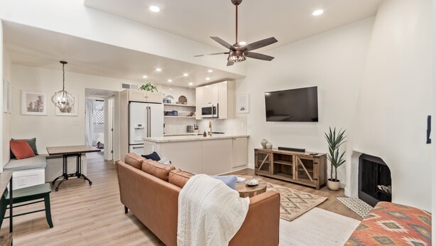 A modern living room with a sofa, a coffee table, and a fireplace.