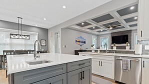 A modern kitchen with grey cabinets, a white countertop, and a built-in dishwasher. - The White House DC/Arlington (Arlington)