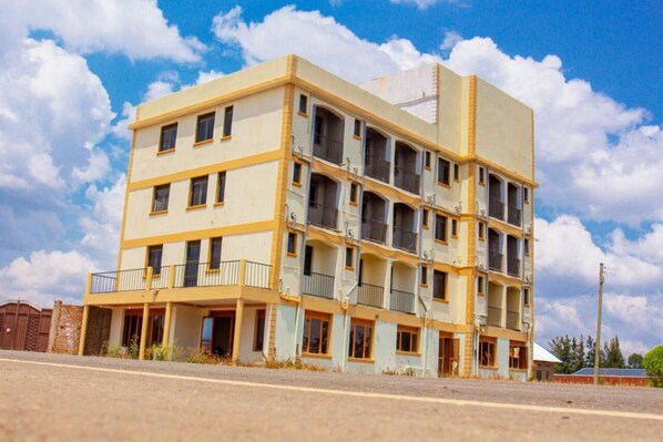 A multi-story building with balconies and a flat roof.