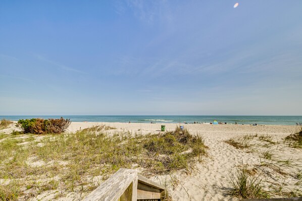 Enjoy a peaceful beach day with a serene view of the calm sea and sandy shore.