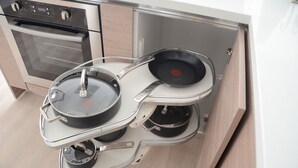 Cozinha com forno embutido e suporte para duas frigideiras.