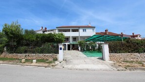 Un bâtiment à deux étages, doté d’une entrée couverte et d’un mur en pierre à l’avant.