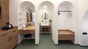 A modern bathroom with a wooden vanity, a sink with a mirror, and a bench. - SARTORI CONCEPT HOTEL (Heraklion)