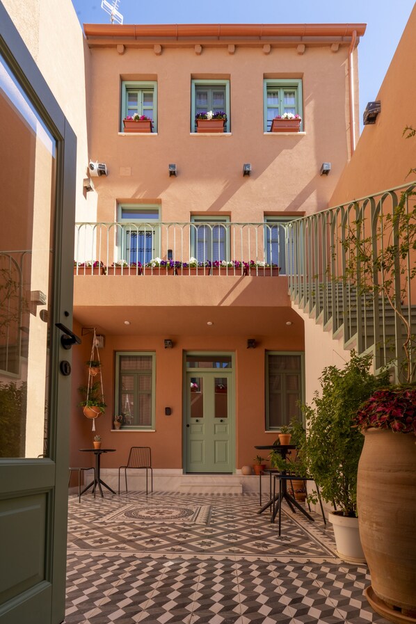 A building with a green door, a balcony with railings, and potted plants. - SARTORI CONCEPT HOTEL (Heraklion)