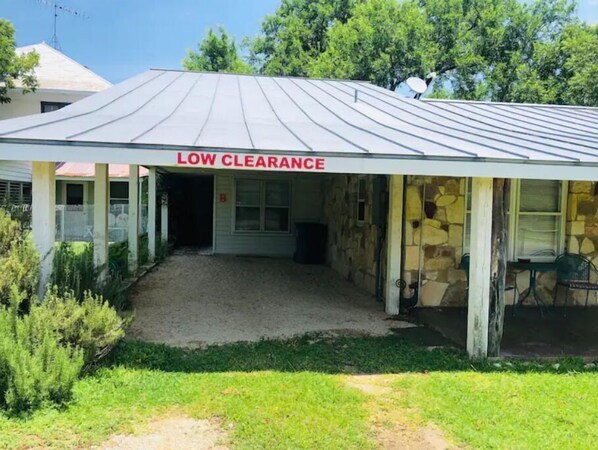 A building with a 'LOW CLEARANCE' sign, a covered entrance, and a stone exterior.