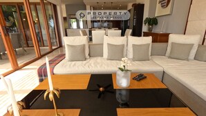 Een moderne woonkamer met een modulaire bank, een bijzettafeltje en een decoratieve vaas met bloemen.