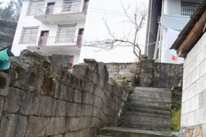 A stone staircase leading up to a building with multiple balconies. - Caiyin Inn (Zhangjiajie)