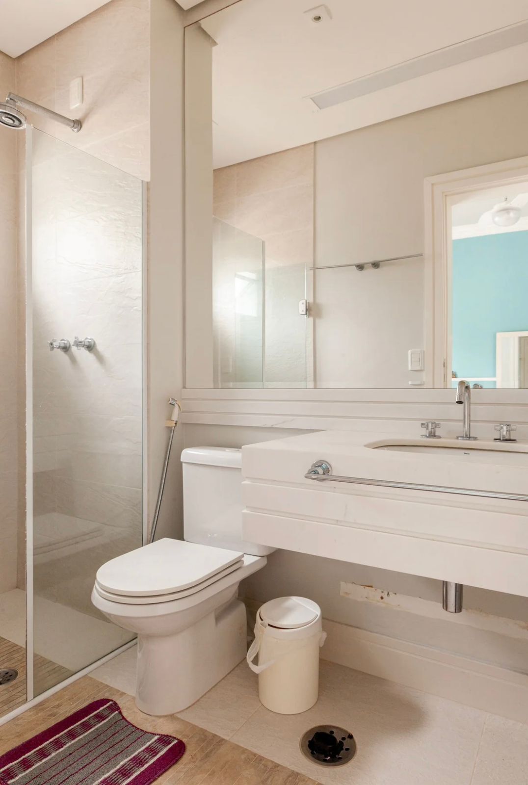 Une salle de bain moderne avec une douche à parois de verre, des toilettes, un lavabo et un miroir.