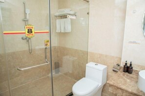 A hotel bathroom with a glass shower enclosure, a toilet, and a sink area. - Junyi · Leishen Jingjie E-Sports Hotel (Beijing Yanqing Global Xinyi Department Store) (Beijing)